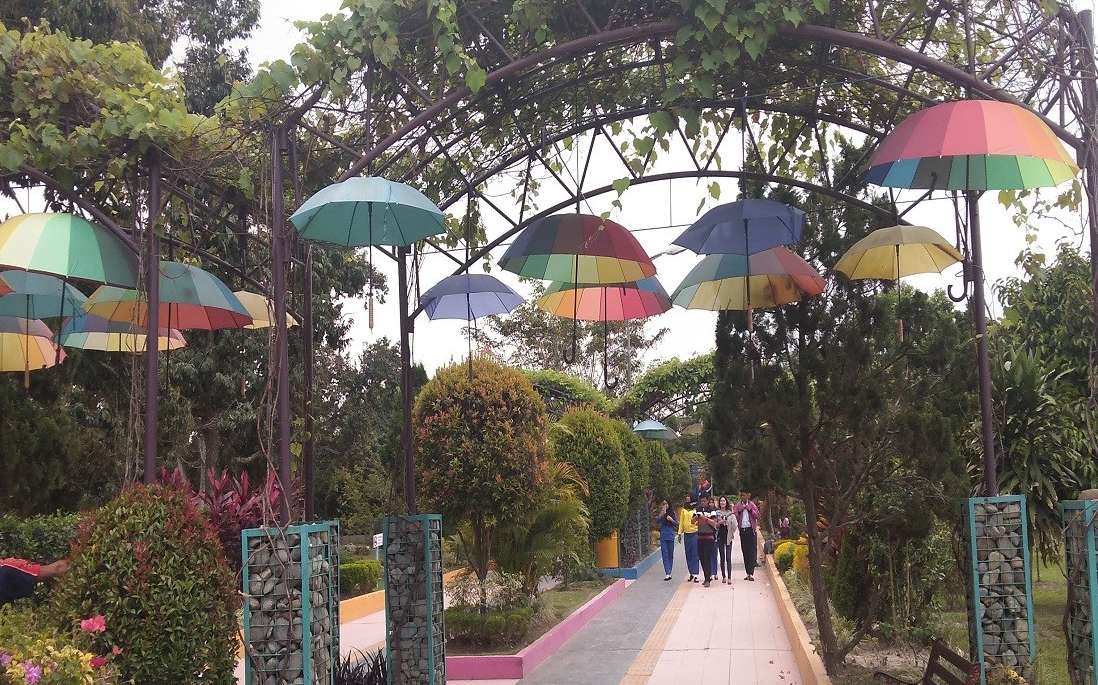 Area taman dengan payung aneka warna tergantung di Taman Buah Lubuk Pakam