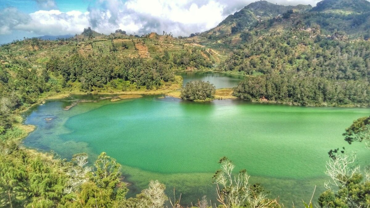 panorama bukit dan danau berwarna hijau toska