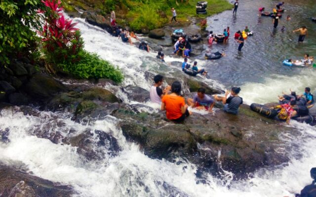 pengunjung berenang di air terjun