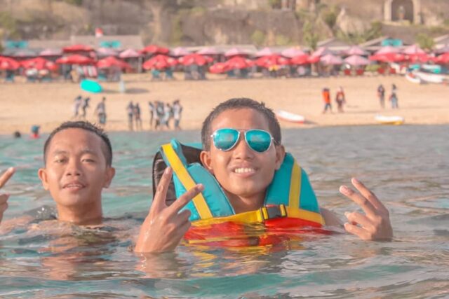 wisatawan yang sedang berenang di pantai pandawa
