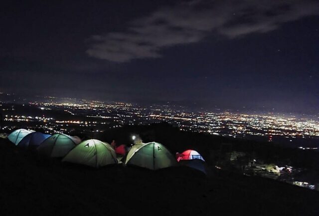 suasana malam berkemah di bukit tranggulasih dengan pemandangan city light