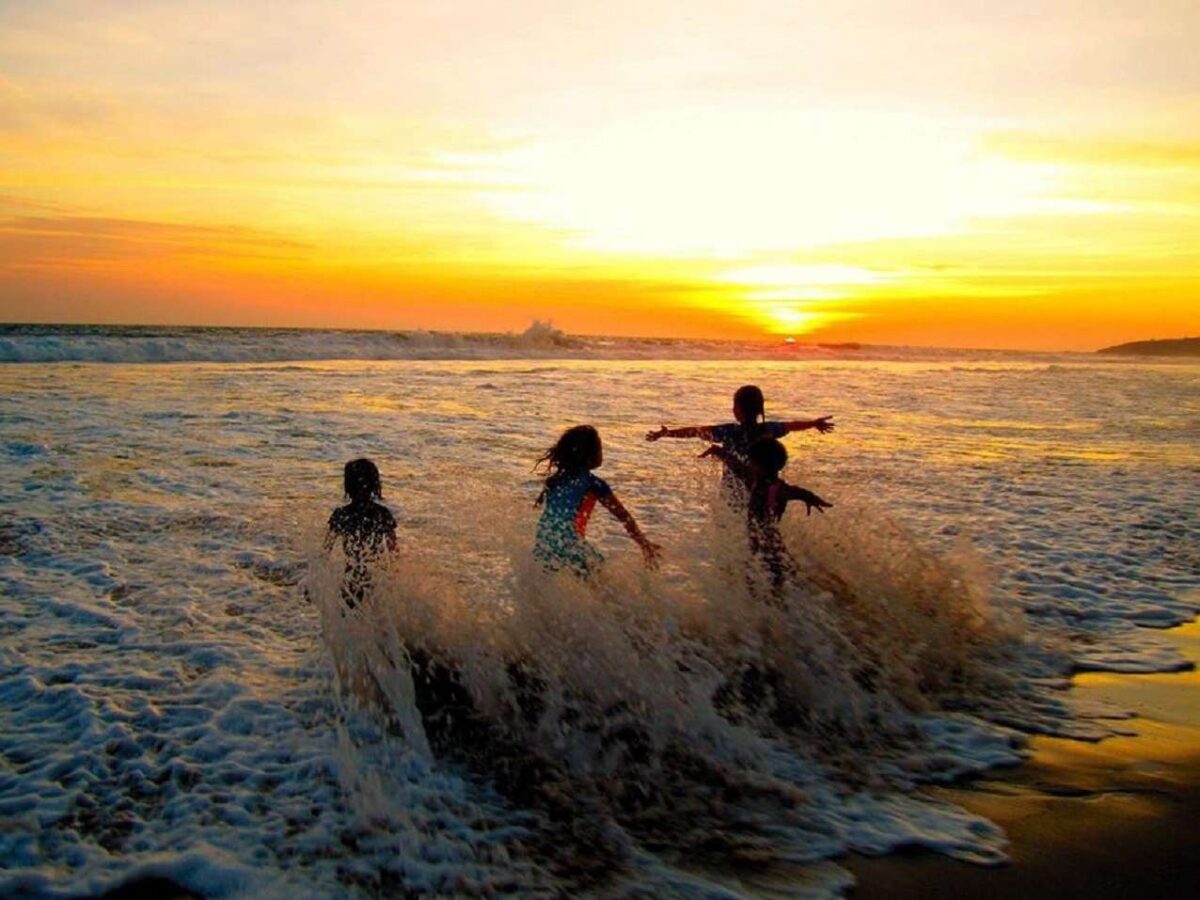 bermain air dan pasir di area pantai sawarna