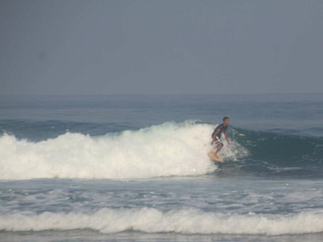 menantang ombak bermain surfing