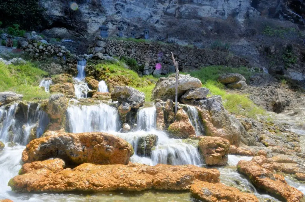 Air Terjun Seganing Klungkung Bali dikelilingi batu-batu cadas berwarna kuning kecoklatan - Bliyan Aryana