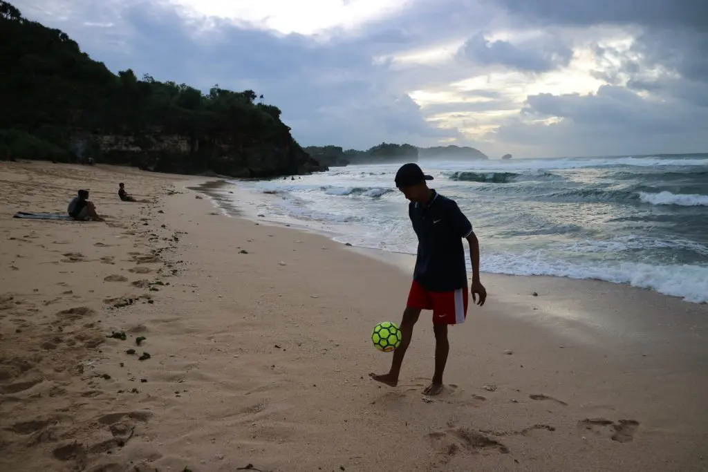 Bermain bola di tepi pantai