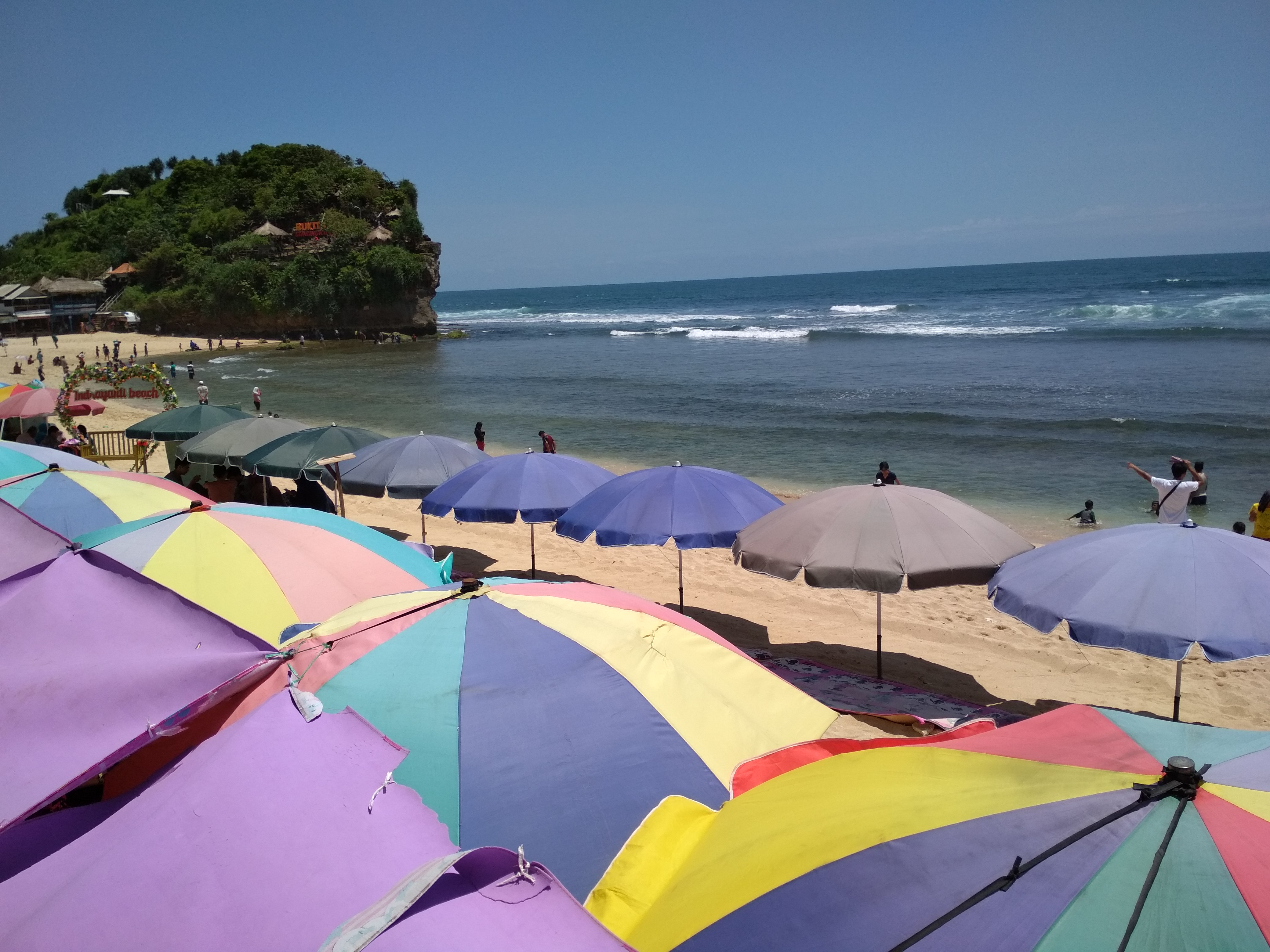 kursi-kursi dan payung pantai tempat bersantai