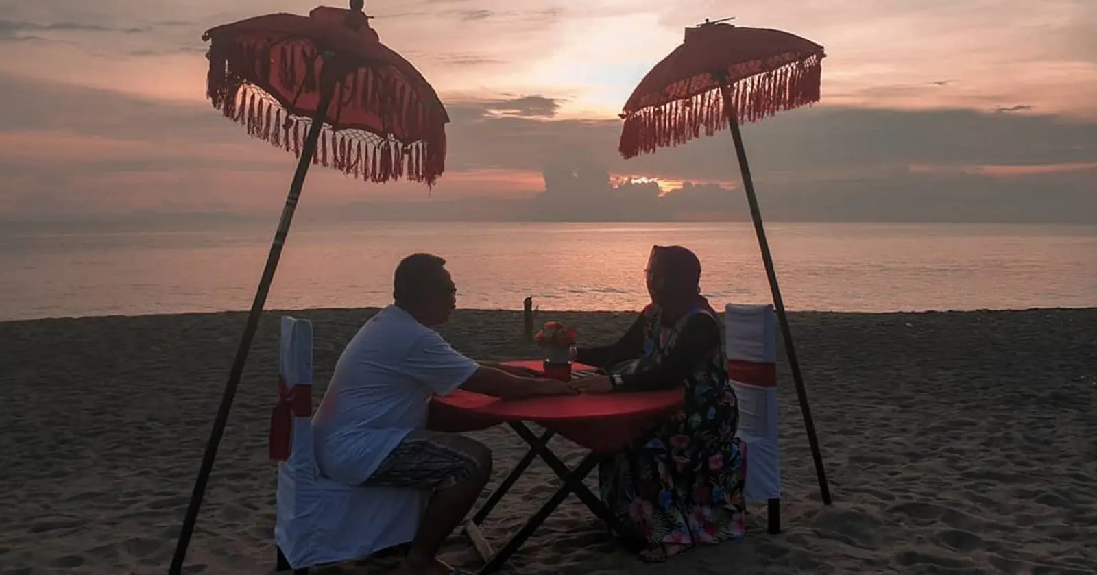 Menikmati romantisnya suasana momen terbenamnya matahari di cakrawala laut Pantai Senggigi Lombok Barat NTB - koko_brengs