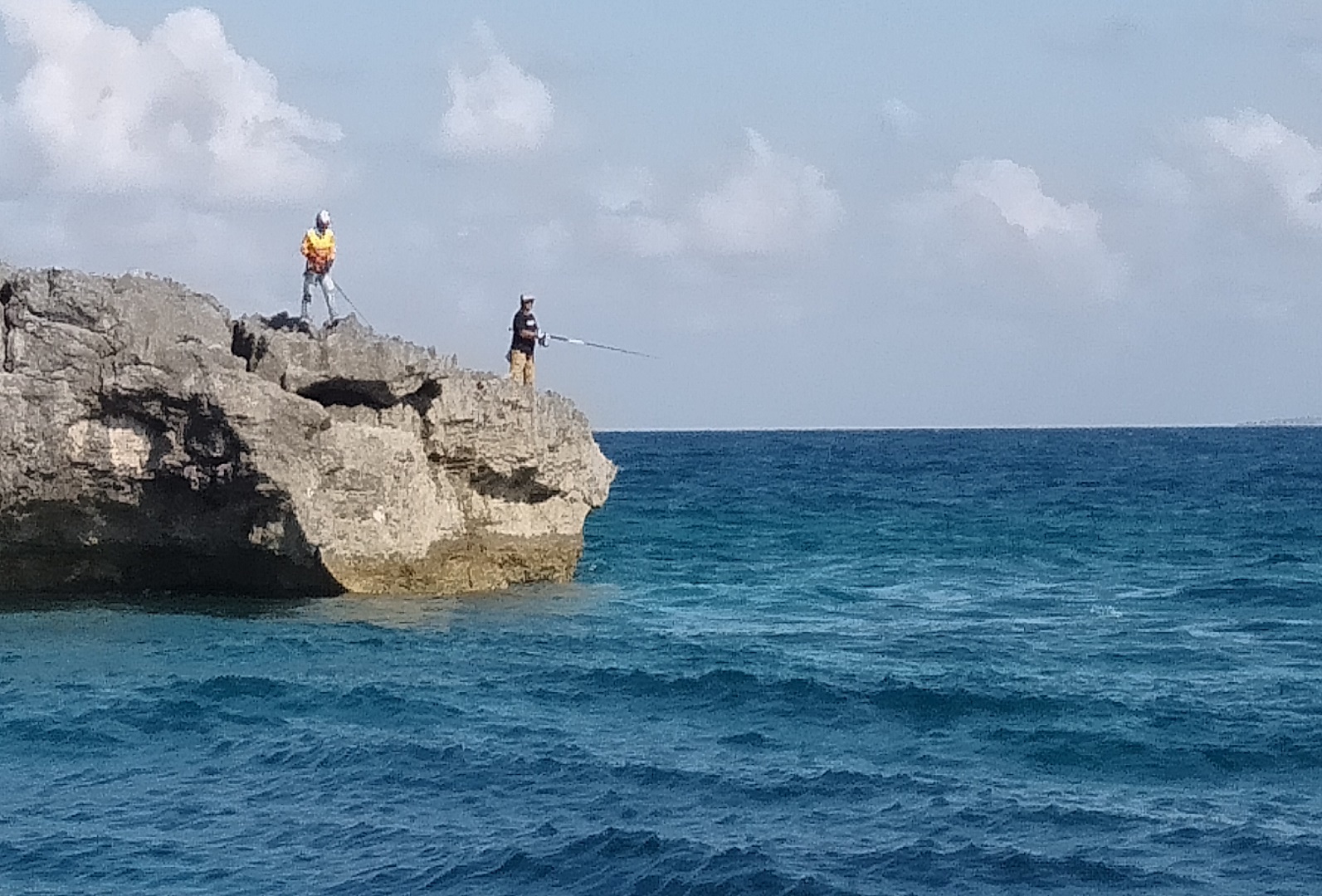 wisatawan memancing di atas karang sektiar pulau