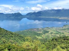 Bentang alam danau maninjau dikelilingi perbukitan hijau