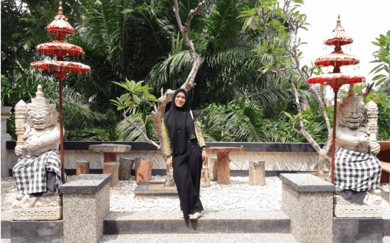 Berfoto dengan patung di T Garden