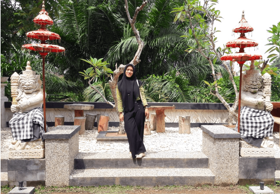 Berfoto dengan patung di T Garden