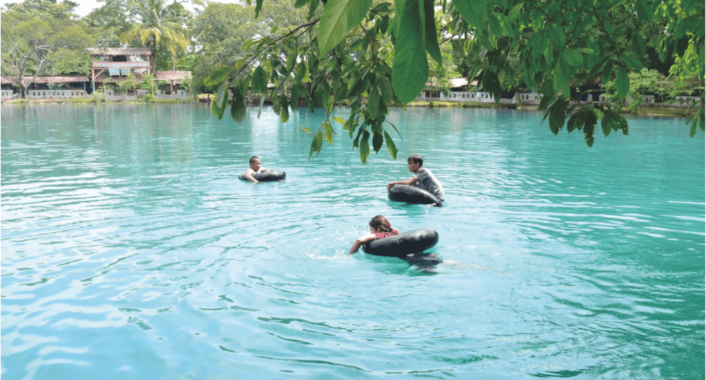 Pengunjung berenang di pinggir danau