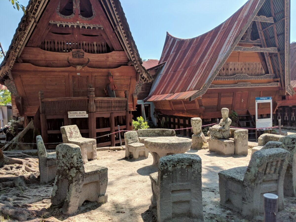 area batu kursi berlatar rumah adat batak