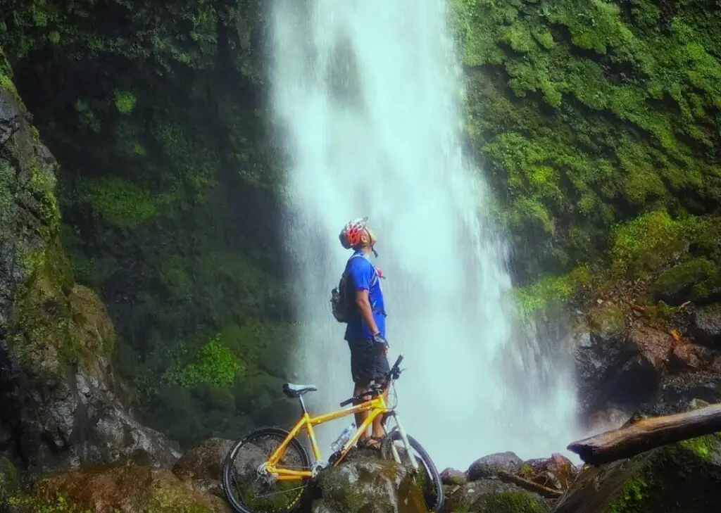 pengunjung bersepeda ke lokasi air terjun