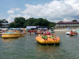 Pengunjung tengah bermain ufo boat di Pantai Pasir Putih Parbaba