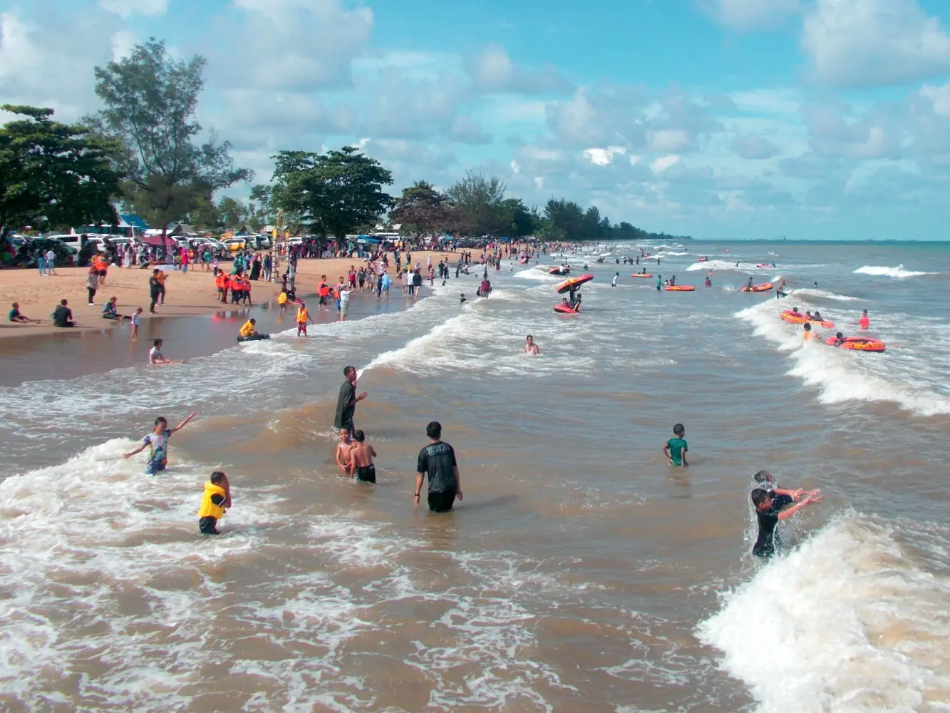 Ramai pengunjung bermain di tepi pantai
