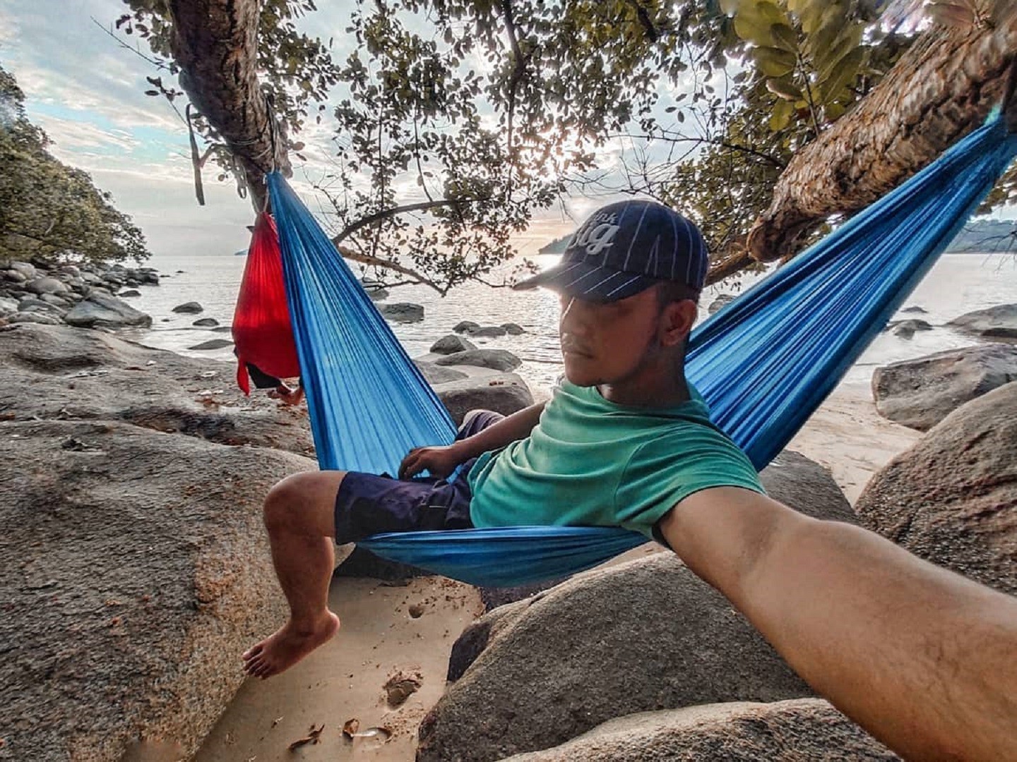 Bersantai di atas hammock di tepi Pantai