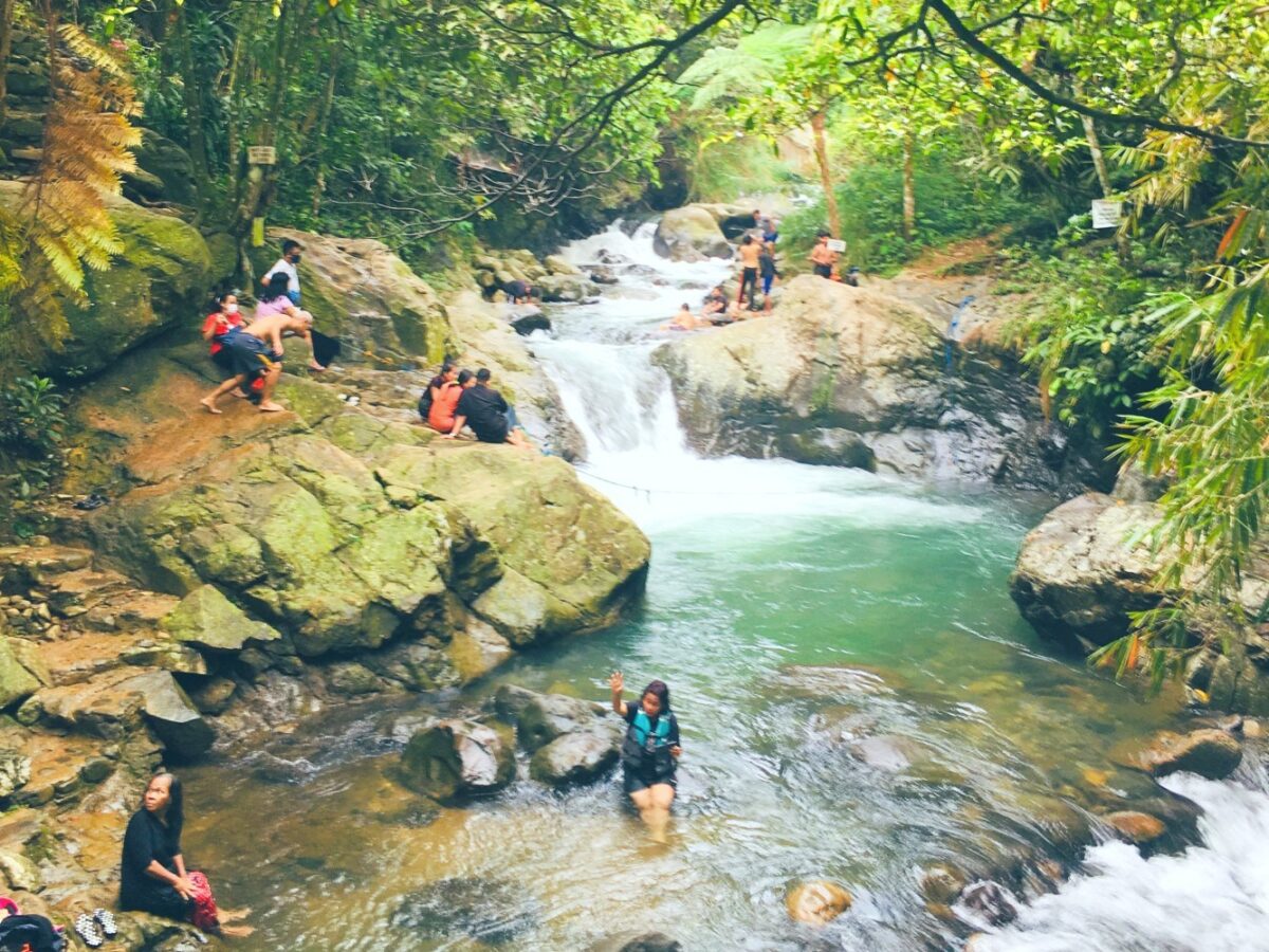 Aliran sungai jernih dengan bebatuan gunung di curug putri kencana