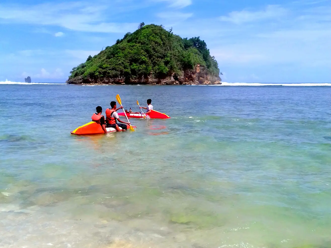 wisatawan bermain kano di area tepi pantai gatra