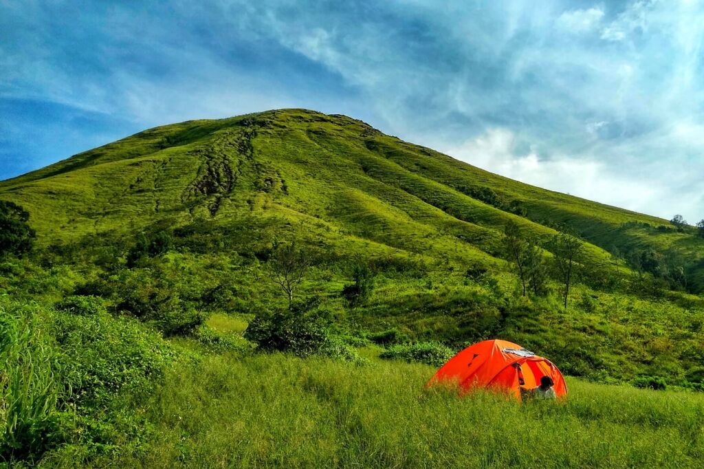 pendaki mendirikan tenda di lereng gunung