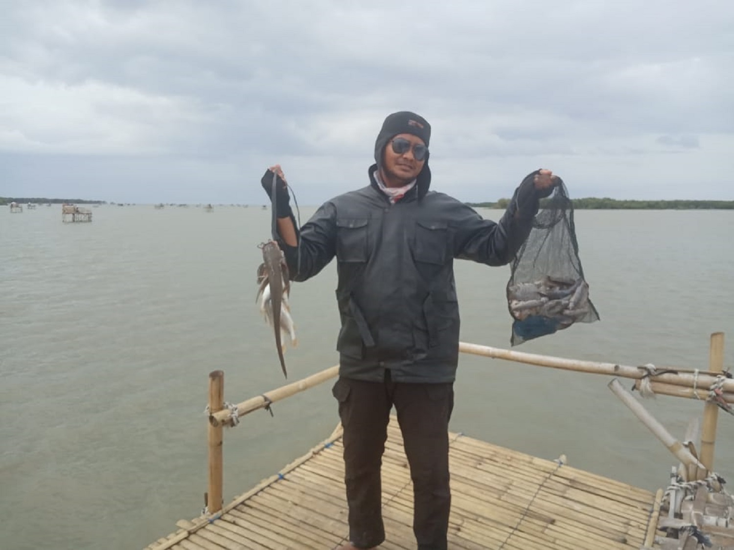 Pengunjung memamerkan hasil tangkapan ikan