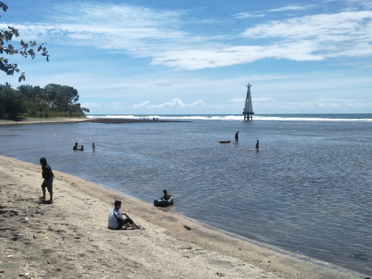 Area tepi Pantai Sindangkerta berlatar mercusuar