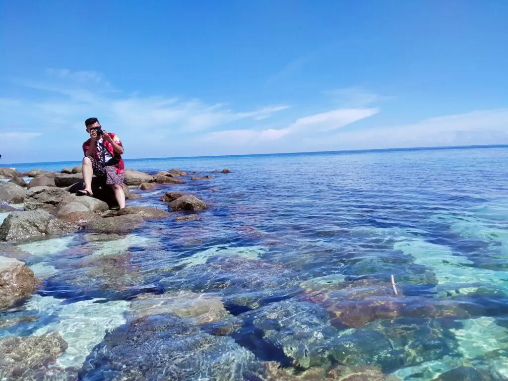 Wisatawan bersantai di batu karang