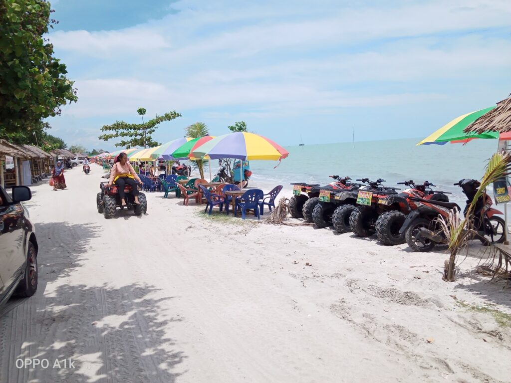 Pengunjung menaiki ATV di kawasan pantai