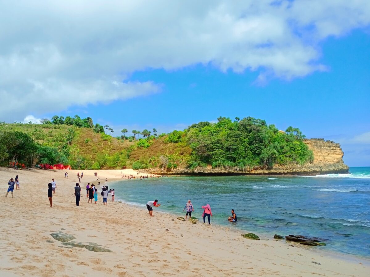 wisatawan bermain di tepi pantai ngudel