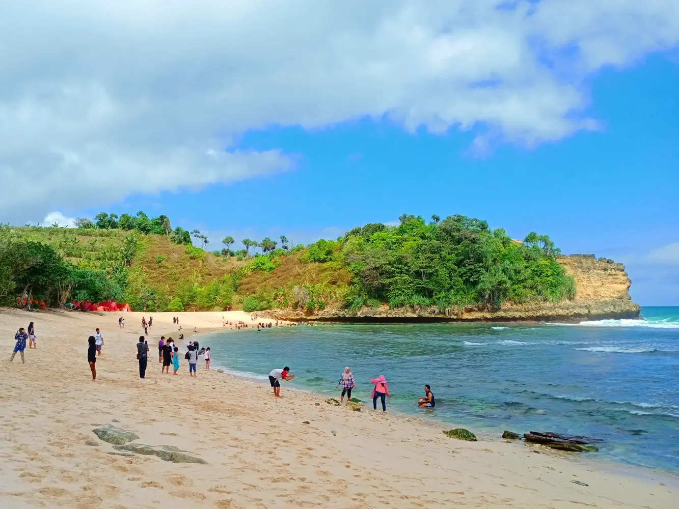 wisatawan bermain di tepi pantai ngudel
