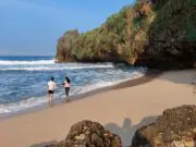 Pengunjung Pantai Ngrawah bermain ombak