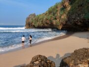 Pengunjung Pantai Ngrawah bermain ombak