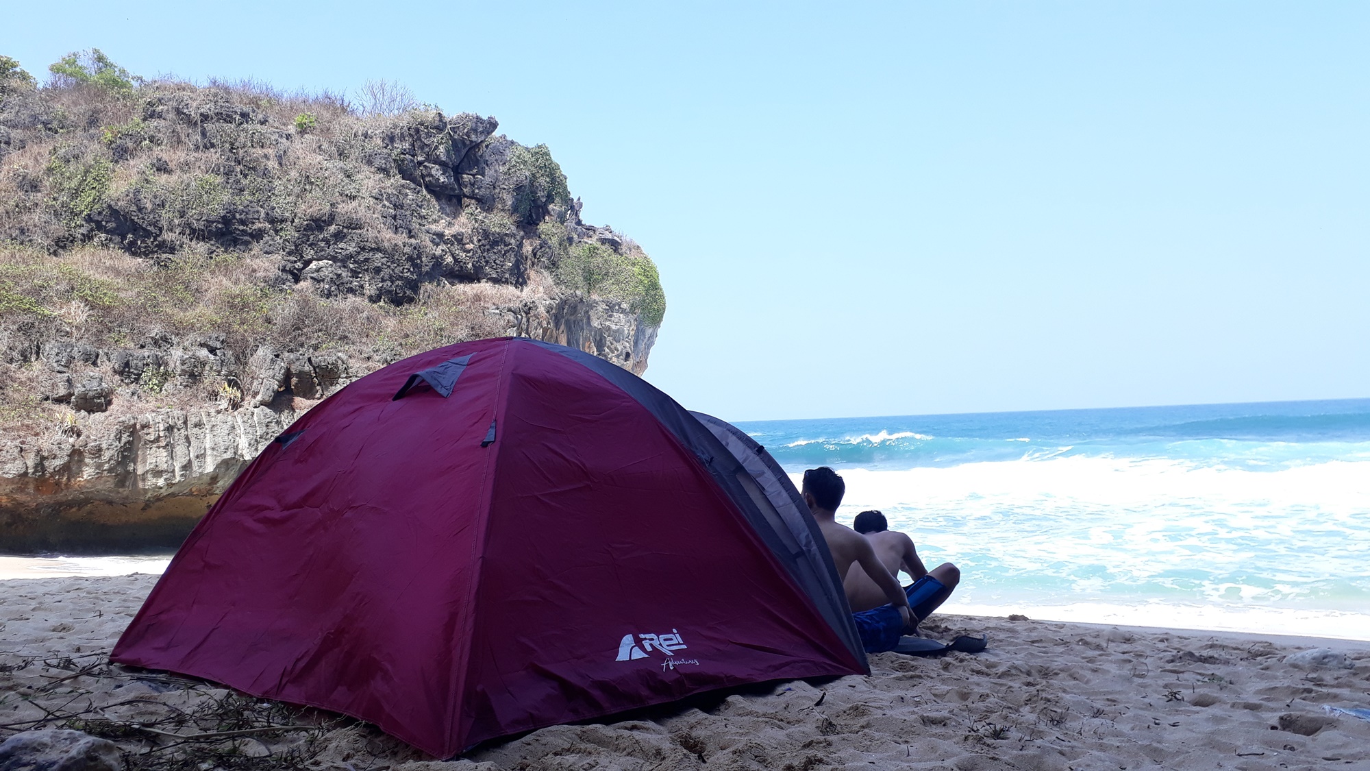 Pengunjung bersantai di depan tenda tepi pantai