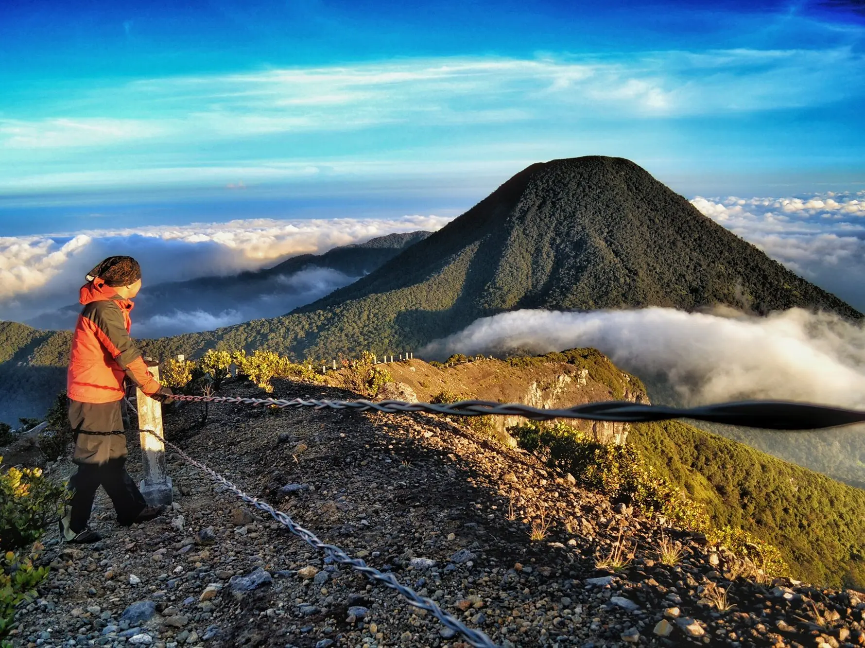 Pengunjung bersandar di pagar pengaman kawah memandangi Puncak Pangrango