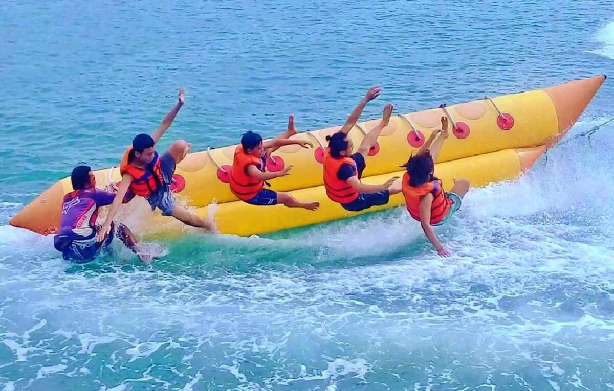 Wisatawan bermain banana boat di Pantai Timur Pangandaran