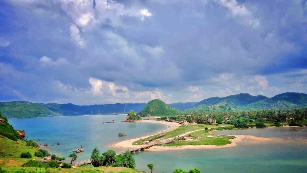 Keindahan pantai seger berlatar perbukitan hijau