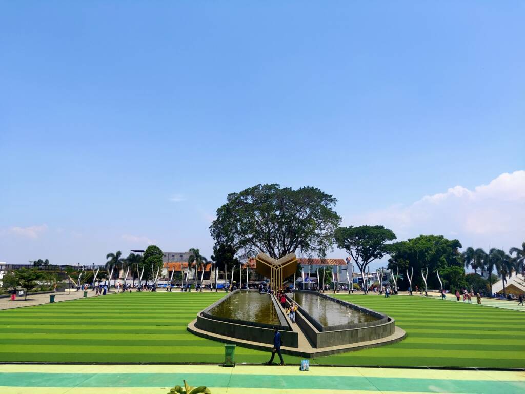 Taman wisata Alun-alun Cianjur dengan air mancur dan rerumputan asli maupun sintetis.