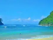 wisatawan bermain di laut biru pantai kwaru
