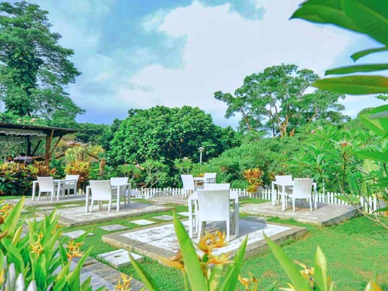 bangku putih berpadu dengan taman hijau di cafe Bataputi Malang