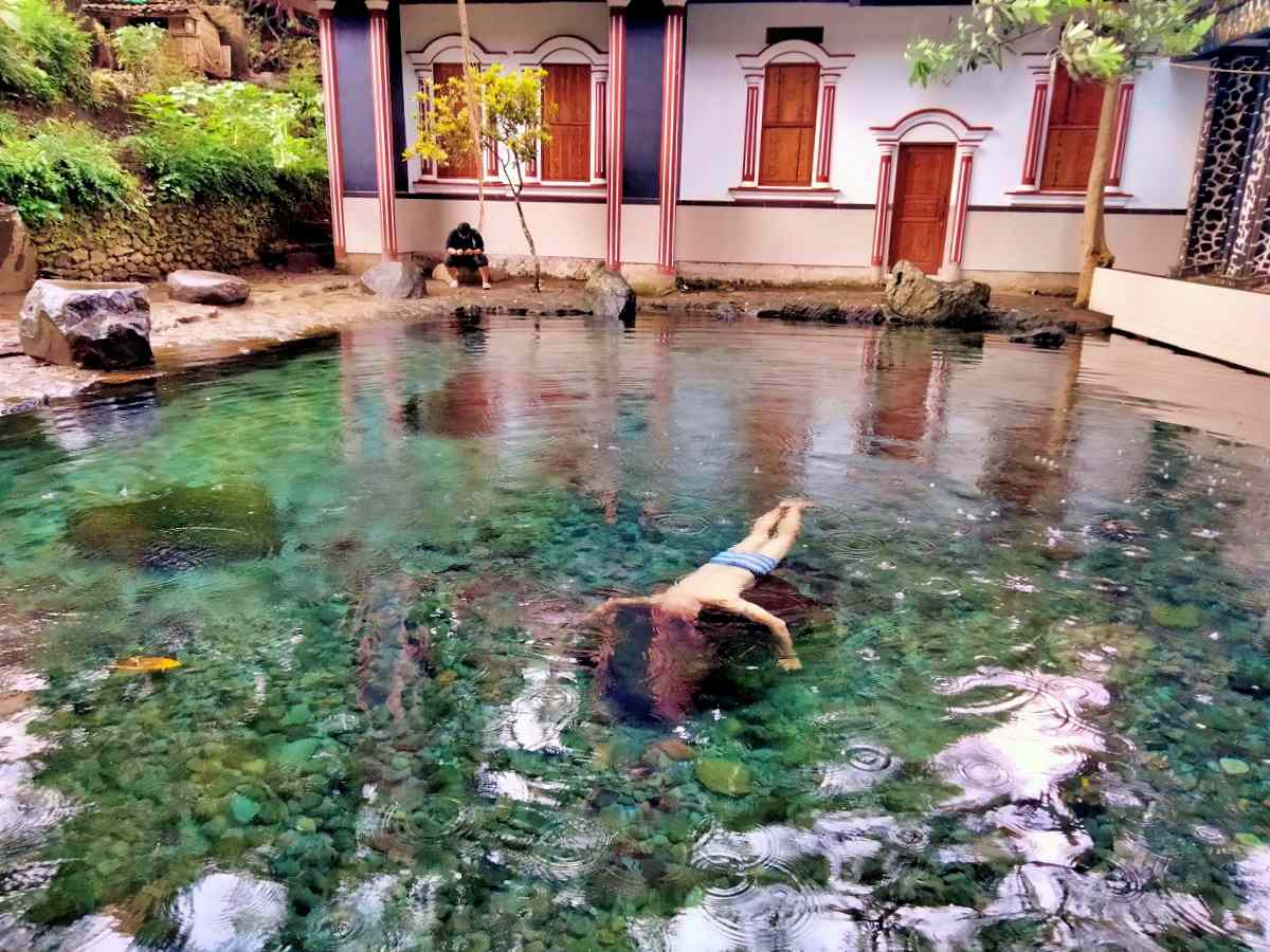wisatawan sedang berenang di kolam jernih Batu Quran