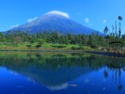 Pemandangan danau dengan latar belakang pegunungan di Embung Kledung