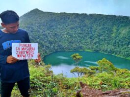 Puncak Gunung Masurai berlatar danau hijau