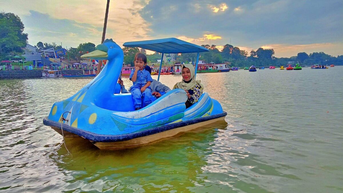 Bermain wahana bebek air di danau sipin