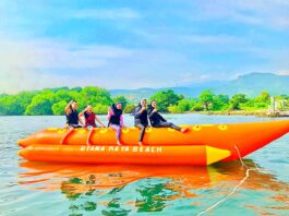 Wisatawan bermain banana boat di pantai utama raya