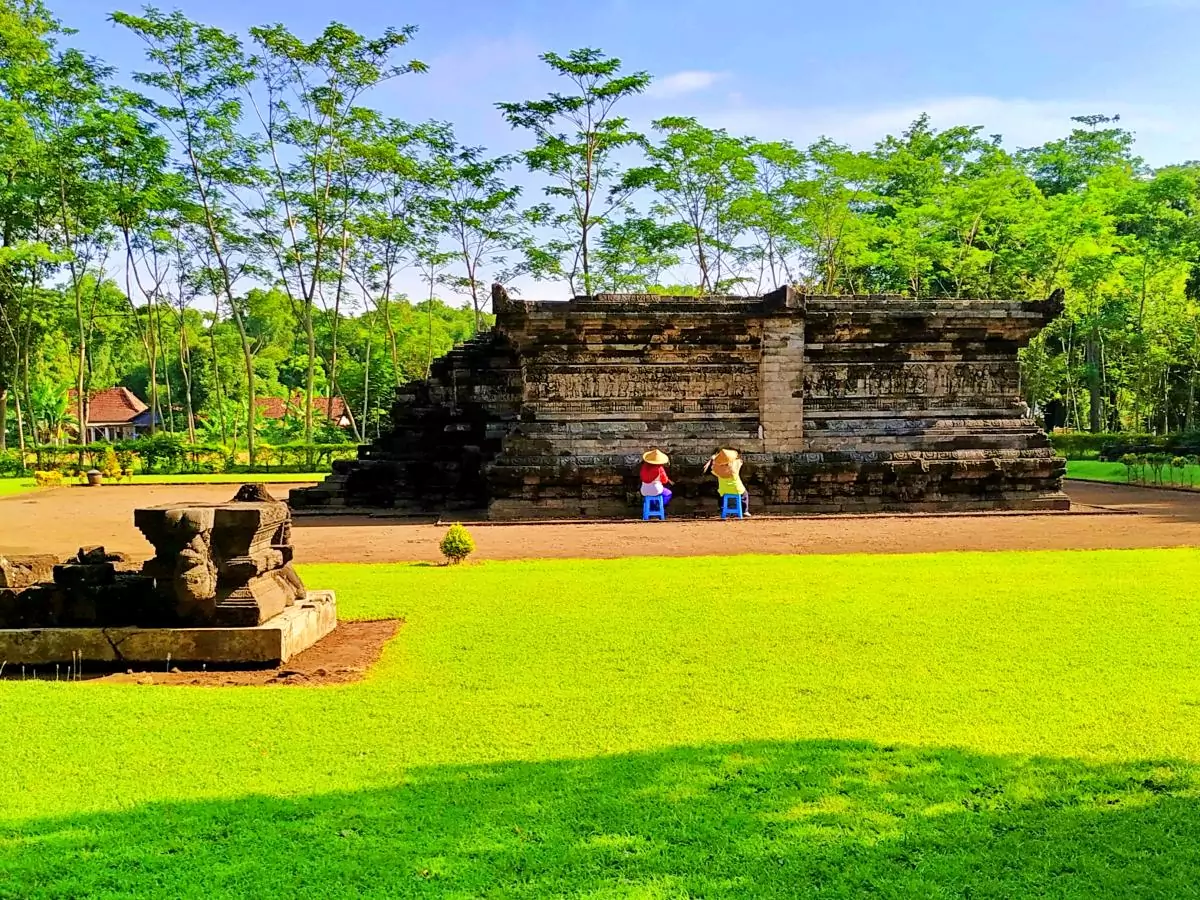 Bangunan candi berdiri di tengah taman yang tertata rapi