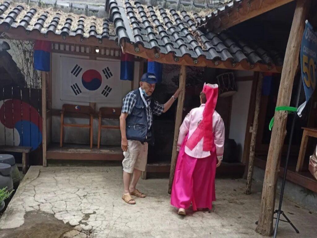 seorang wanita memakai pakaian hanbok masuk ke area Korea paviliun
