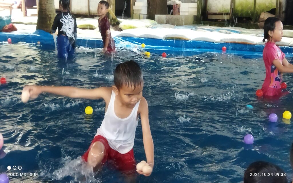 Anak kecil bermain bola di kolam anak Pantai Lumut.