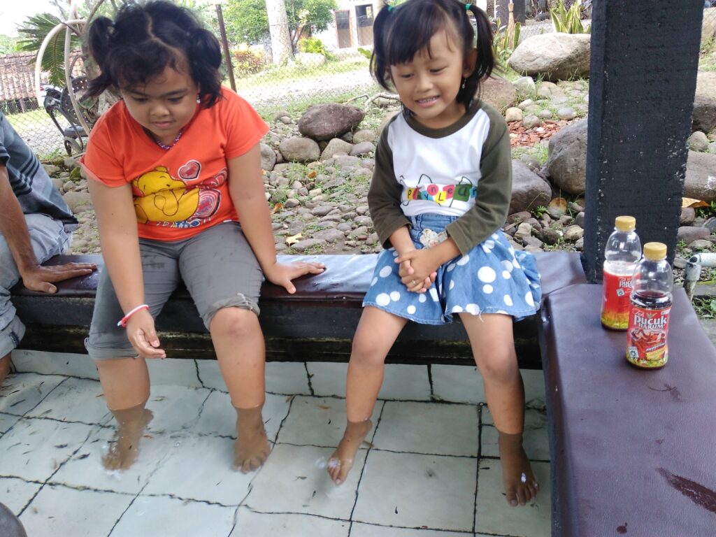 Dua orang anak mencoba kolam terapi ikan Objek Wisata Tlatar.
