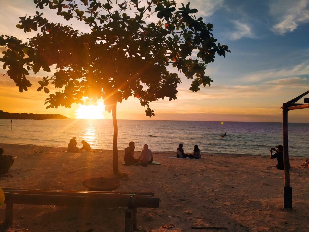 wisatawan sedang melihat sunset di Pantai Kampung Prau.
