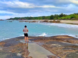 Suasana di Pantai Rambak dengan pasir putih dan hamparan batu granit.